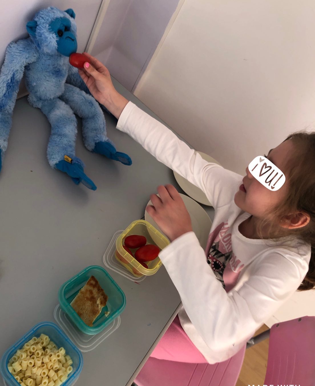 niña dandole de comer a muñeco