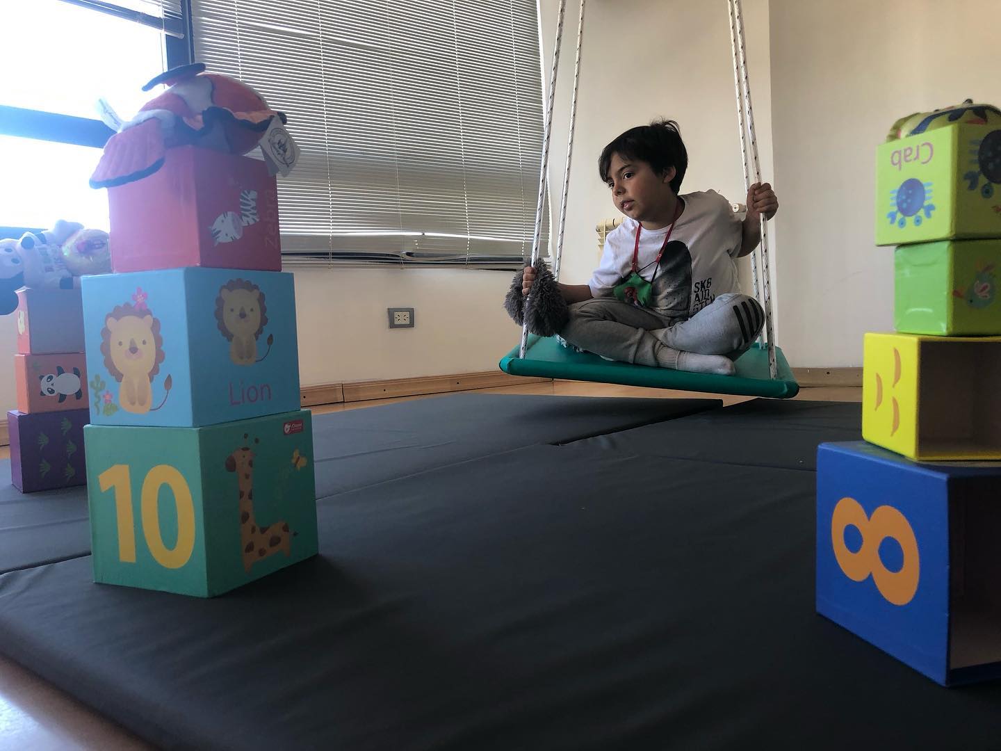 niño en hamaca observando cubos con numeros